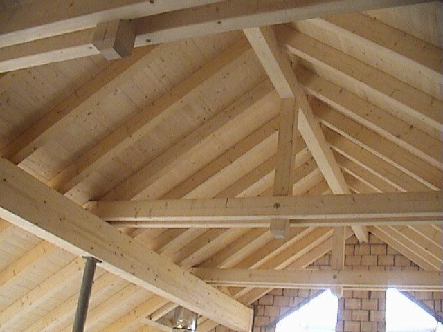Sichtbarer Dachstuhl aus hellem Holz, von innen fotografiert